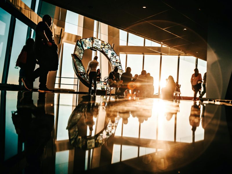 Silhouette of people enjoying sunset views from a modern skyscraper in New York City.